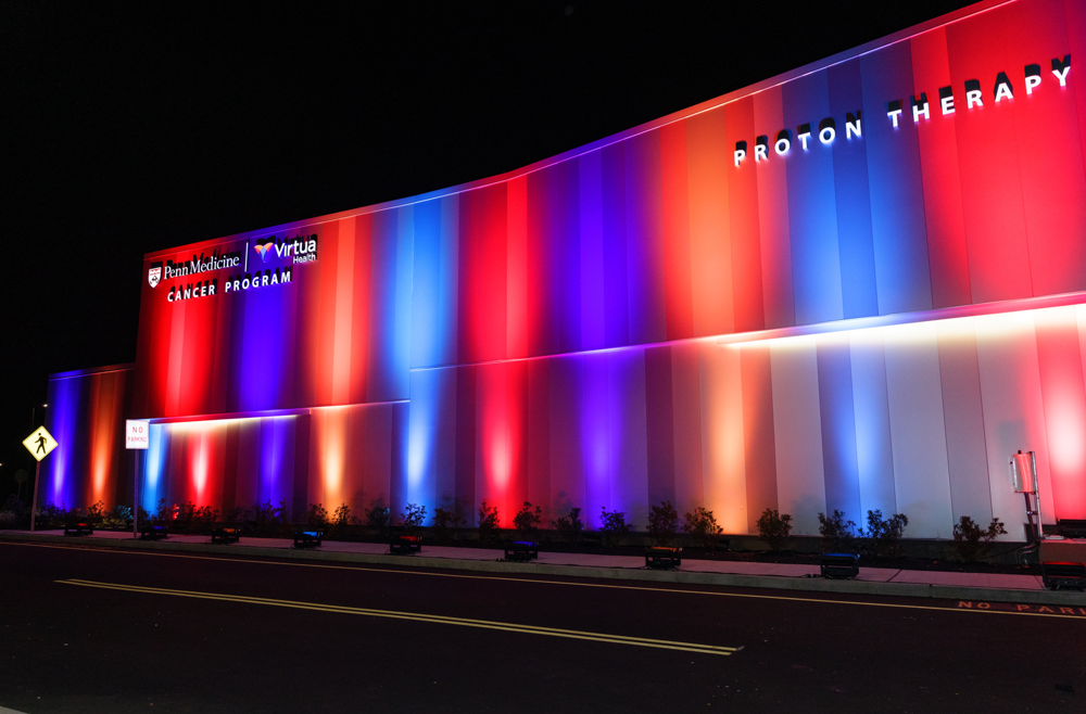 The exterior of the Penn Medicine | Virtua Health Proton Therapy Center, illuminated as a “beacon of hope” as part of the preview celebration.